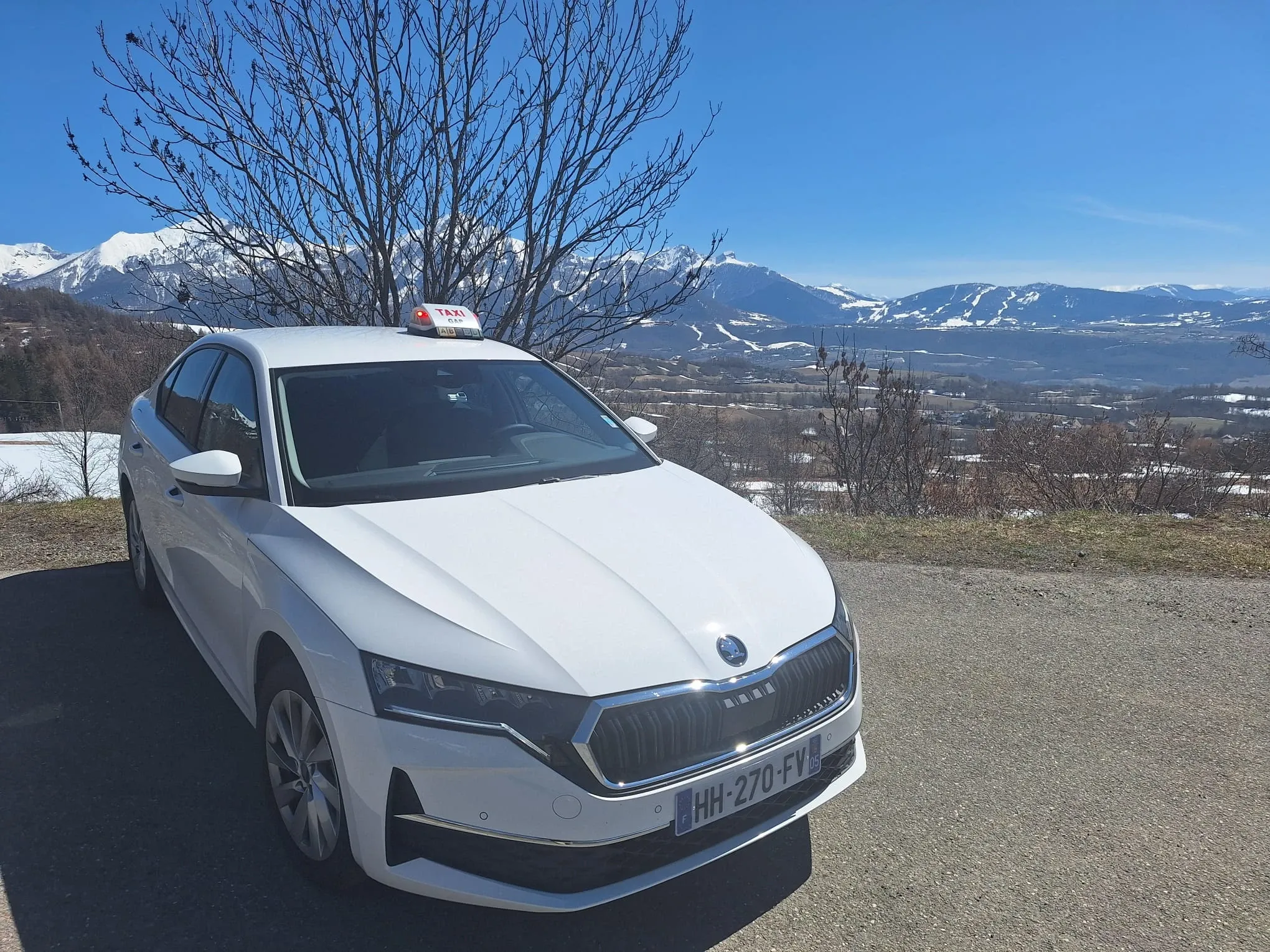 Le taxi Mtaxi face aux sommets enneigés et aux pistes d'une station